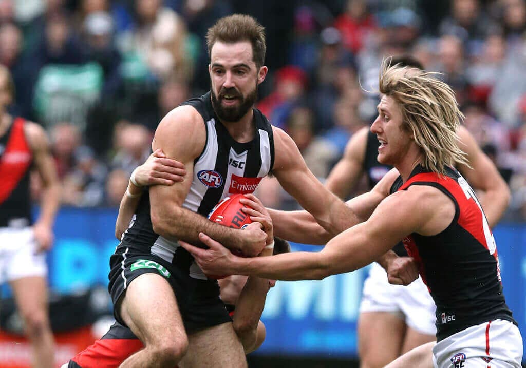 Magpie Steele Sidebottom tackled by Dyson Heppell