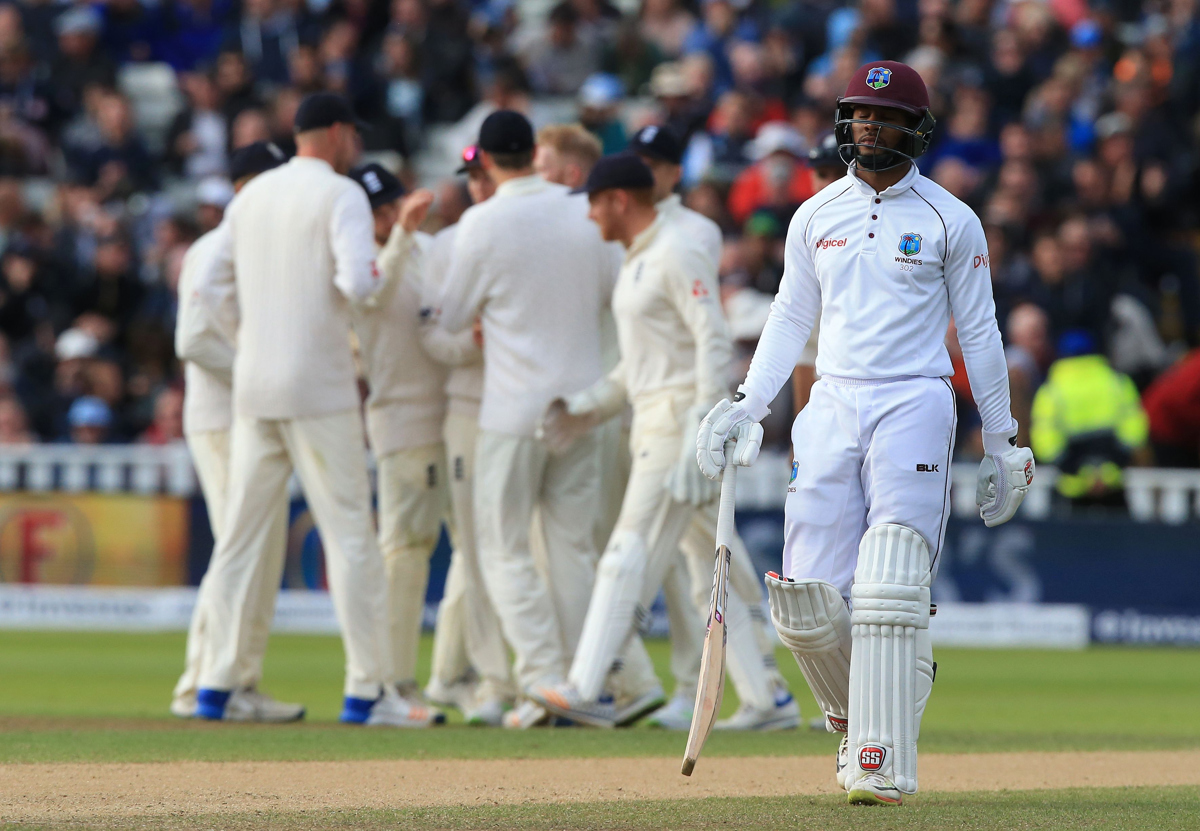 West Indies' Shai Hope (R) walks back to the pavilion after losing his wicket during play on day 3.