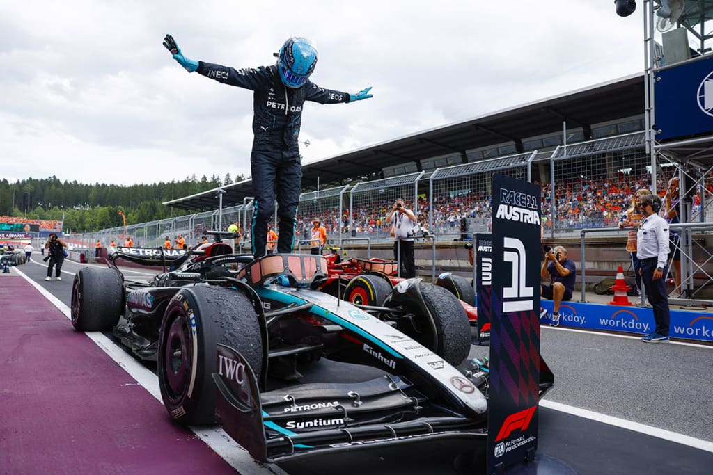 Formula 1 driver stands on his car